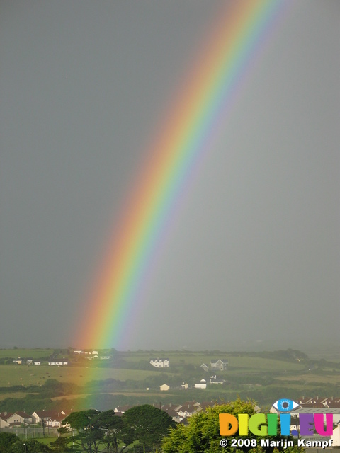 27073 Bright rainbow over green fields and white houses